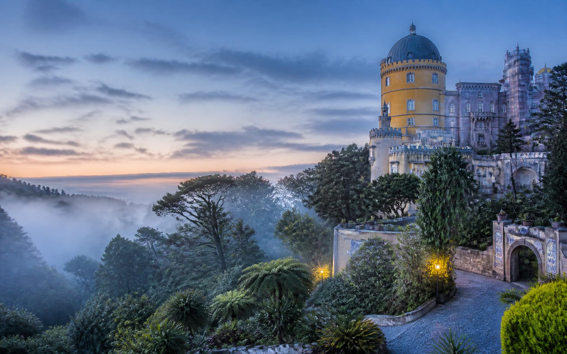 Pena Palace above the misty gardens of Sintra at dawn